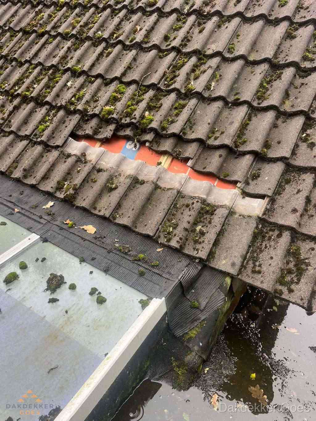 Beschadigd pannendak met ontbrekende dakpannen voor reparatie in Goes