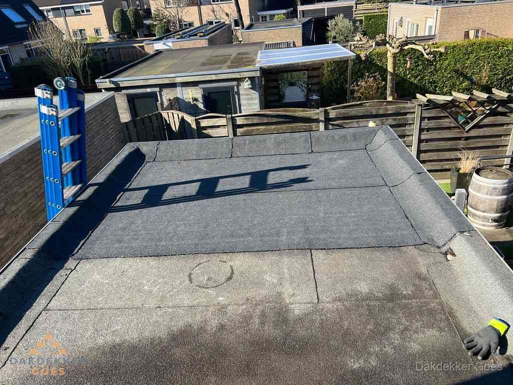 Dakdekker legt onderlaag op plat dak met houten constructie in Goes