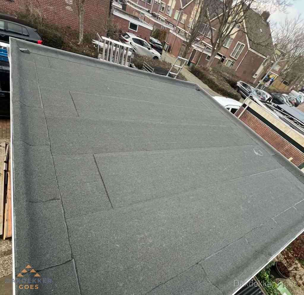 Nieuwe bitumen dakbedekking op plat dak van garage in Goes