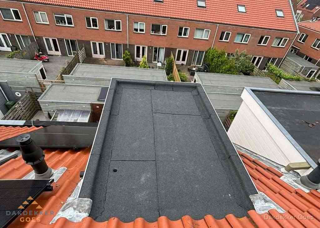 Plat dak met bitumen bedekking naast dakkapel in Goes
