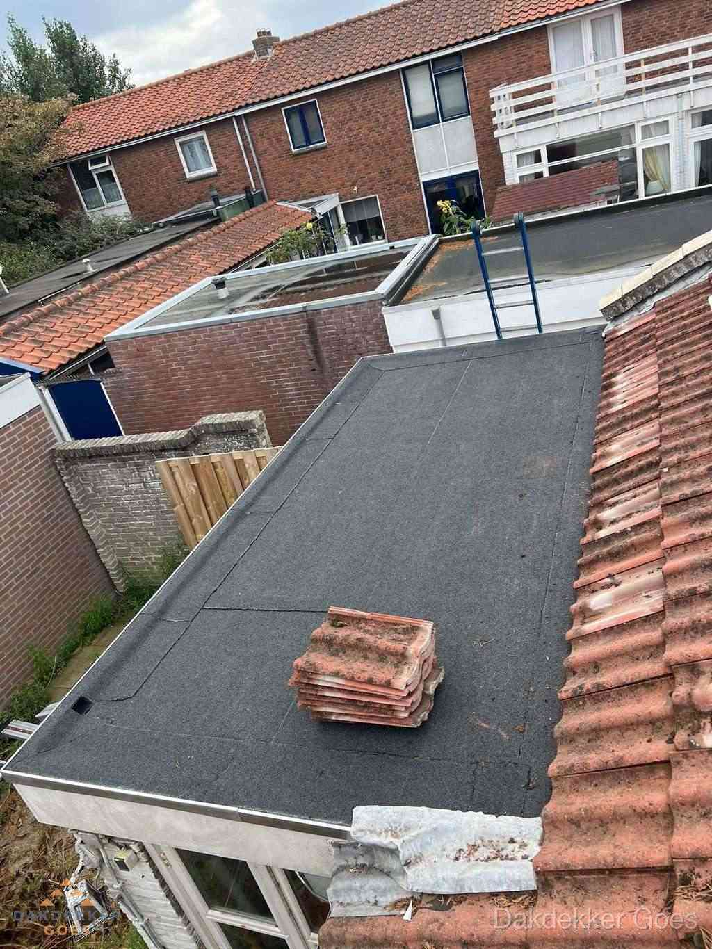 Aanbouw plat dak met reservepannen voor dakpannen vervangen in Goes