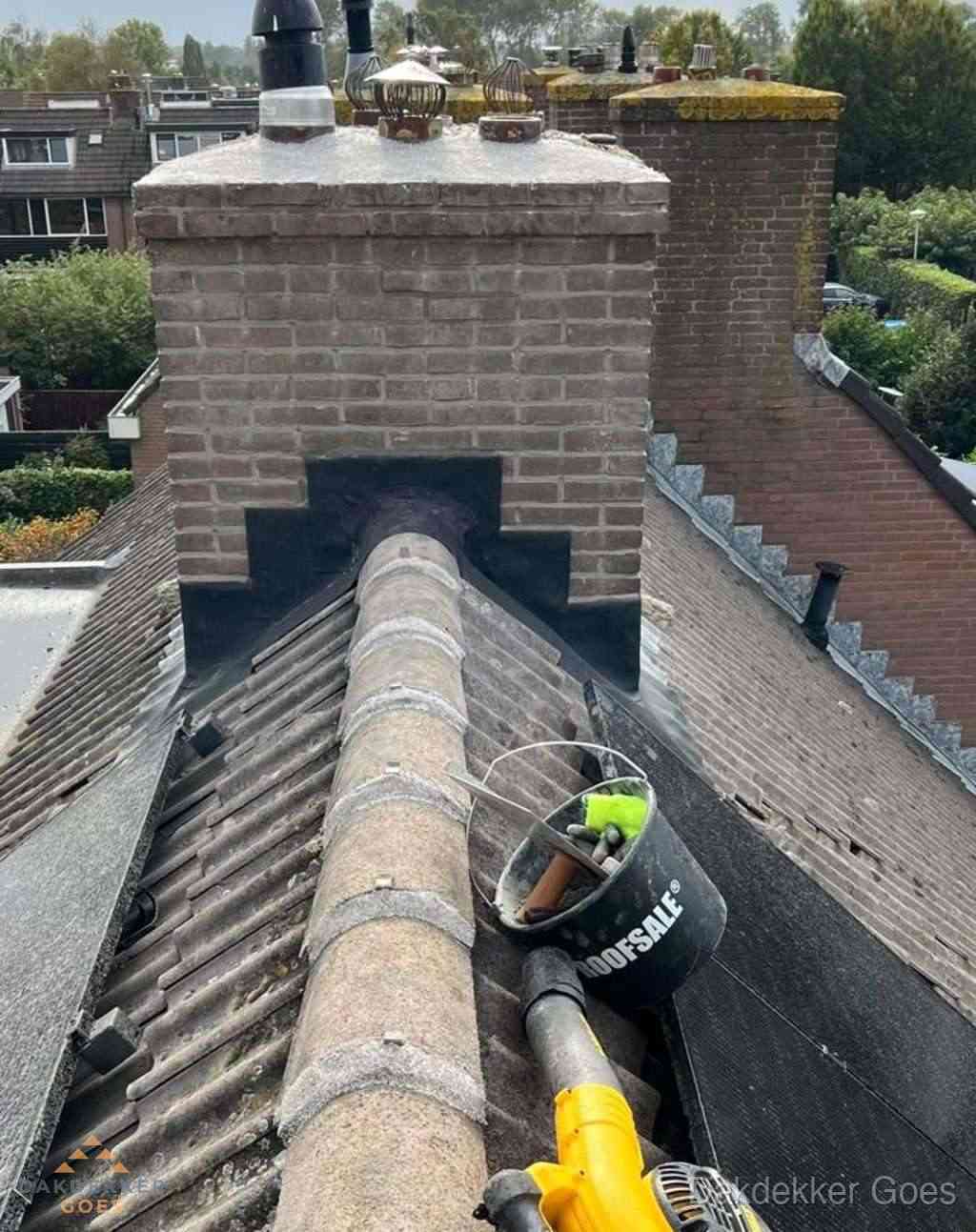 Dakdekker repareert bitumen dakleer bij dakdoorvoer in Goes
